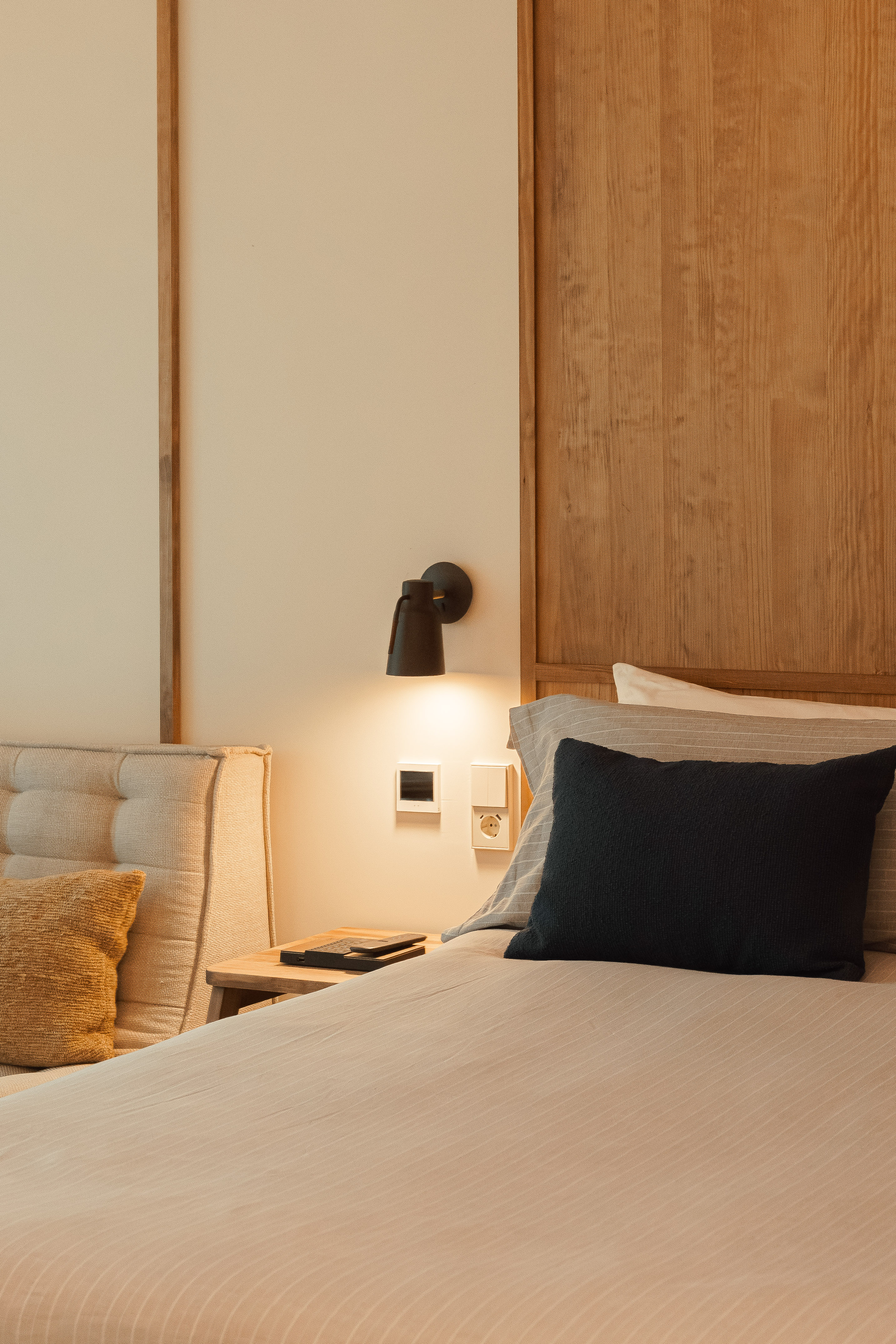 a bed with a black pillow and a wood headboard