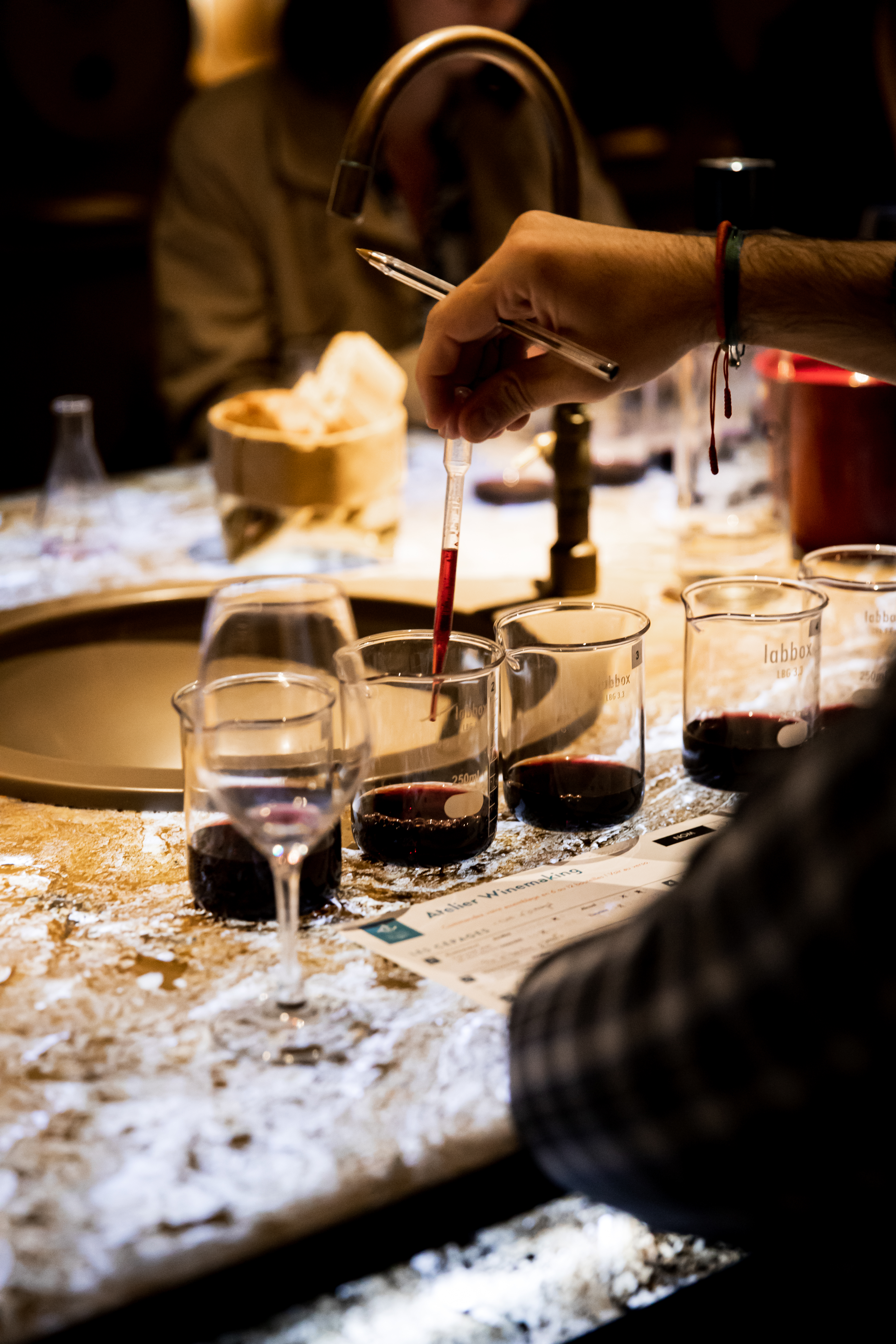 a person pouring liquid into a beaker