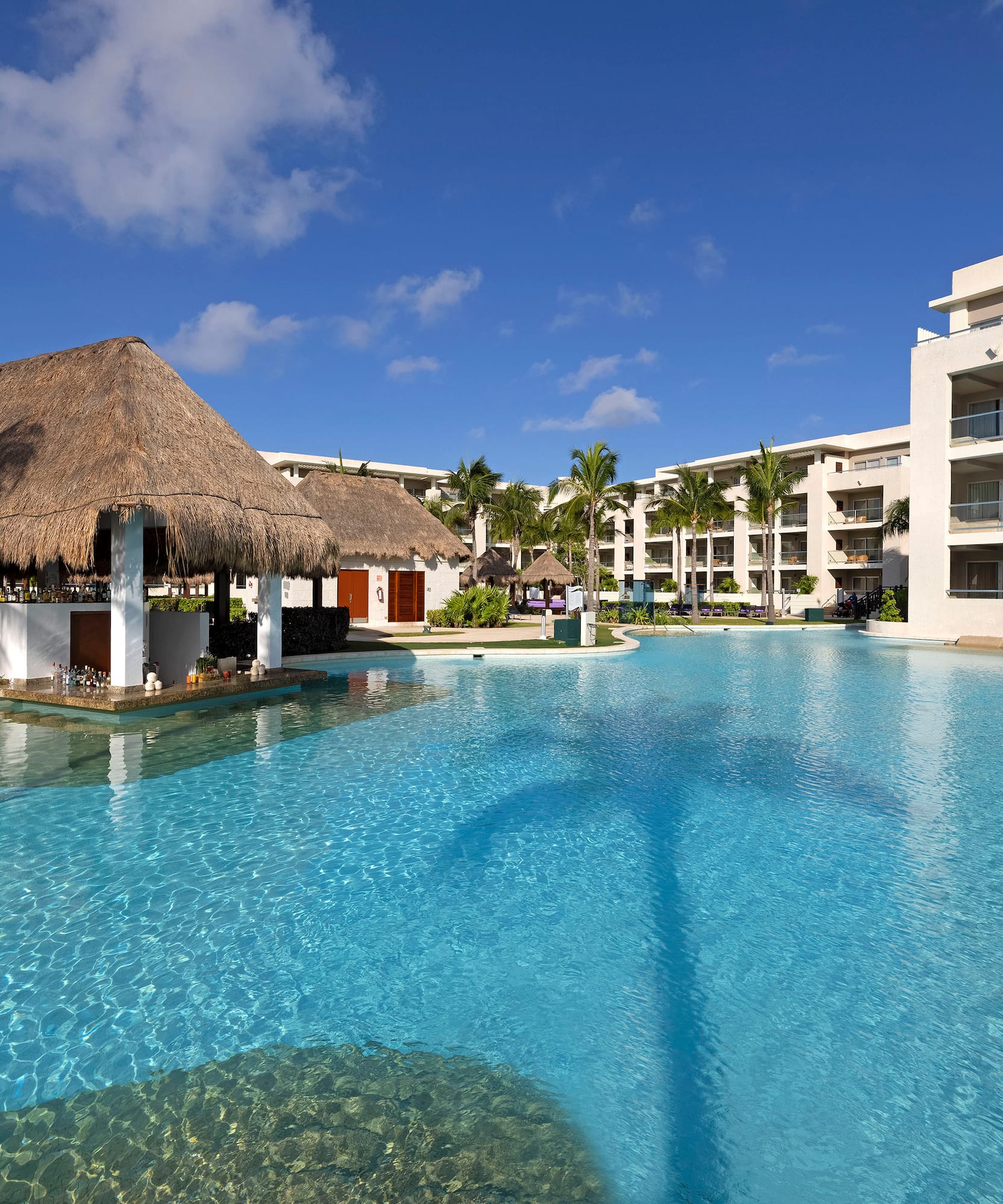 a pool with a thatched roof and buildings