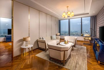 a room with a large window and a couch and chairs
