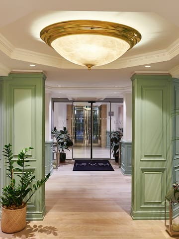 a hallway with green columns and plants