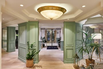 a hallway with green columns and plants