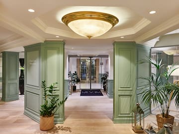 a hallway with green columns and plants