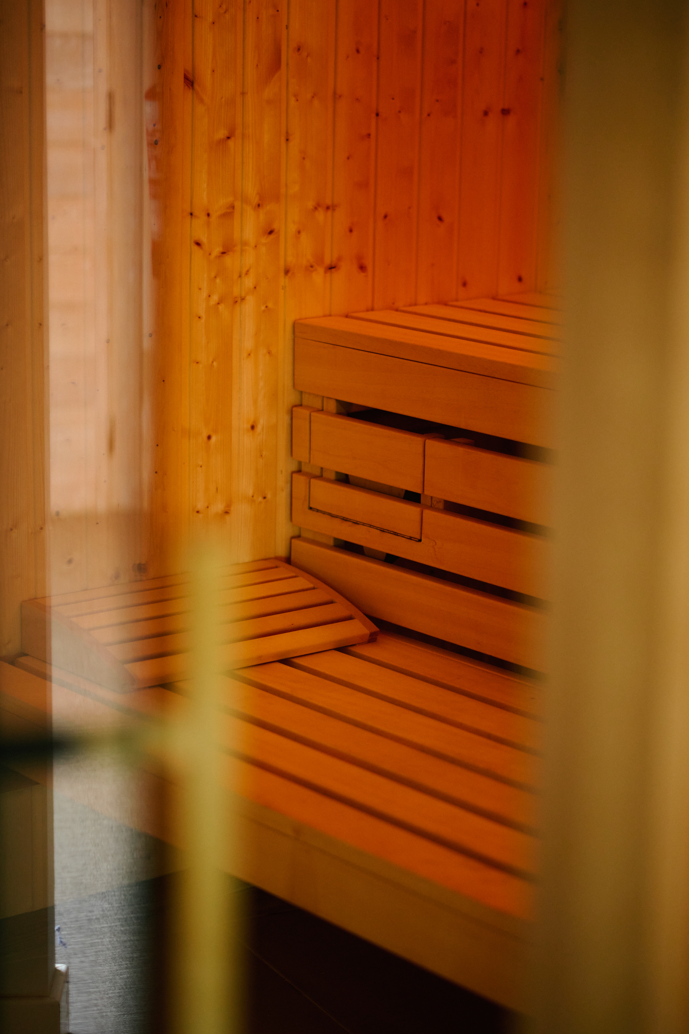 Wooden sauna interior with warm slatted benches.
