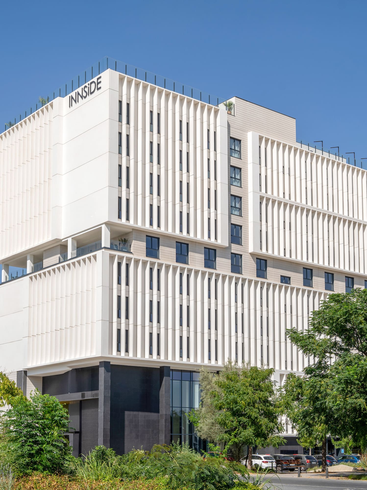 a white building with trees and blue sky