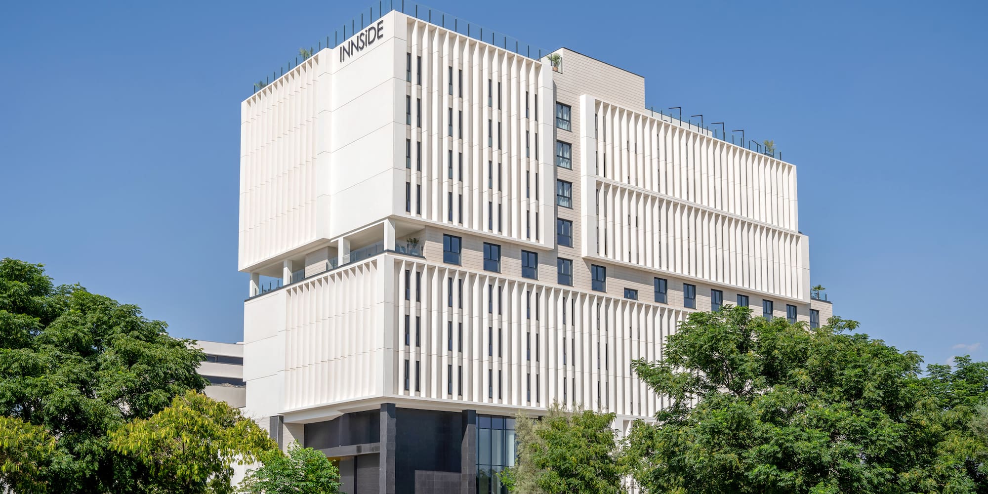 a white building with trees and blue sky