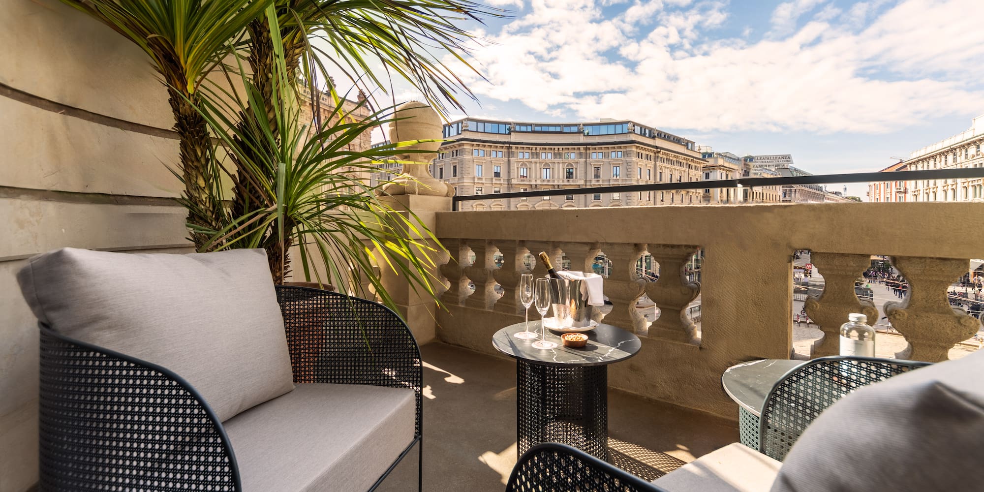 a patio with a table and chairs and a palm tree