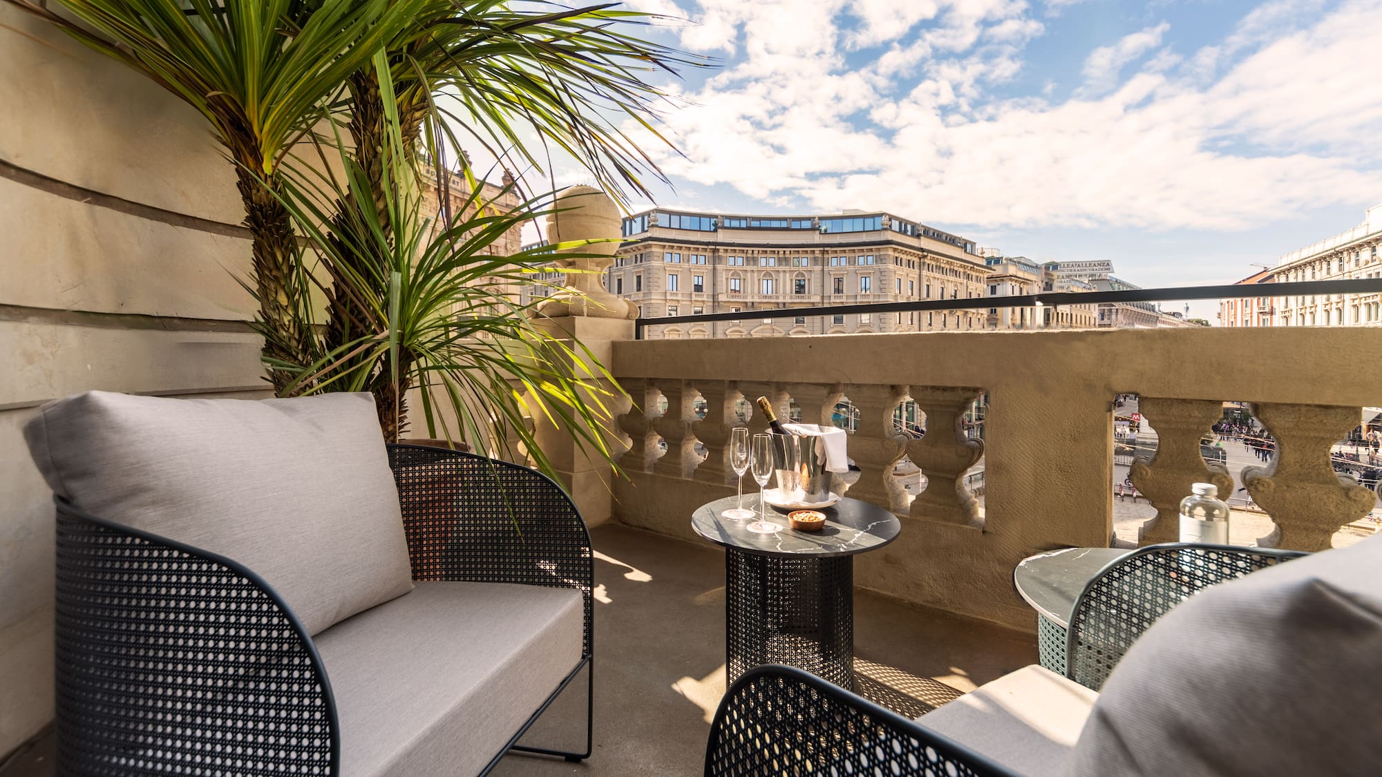 a patio with a table and chairs and a palm tree