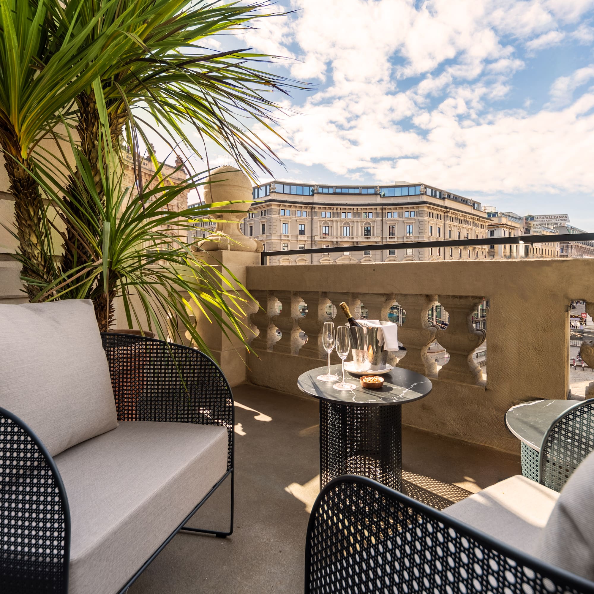 a patio with a table and chairs and a palm tree