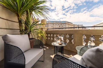 a patio with a table and chairs and a palm tree