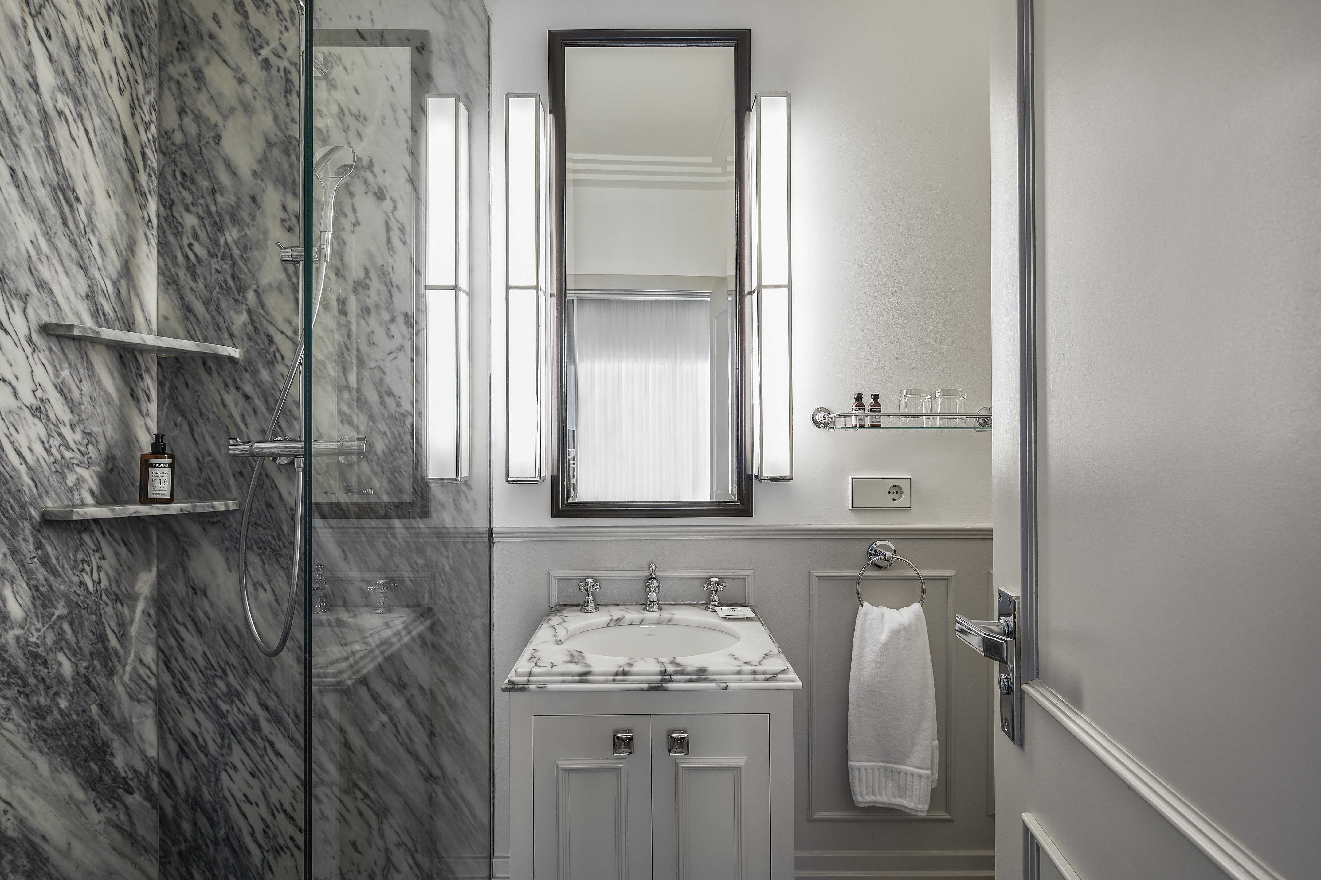 a bathroom with marble walls and a mirror