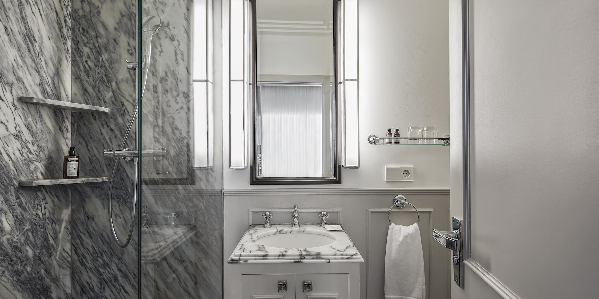a bathroom with marble walls and a mirror