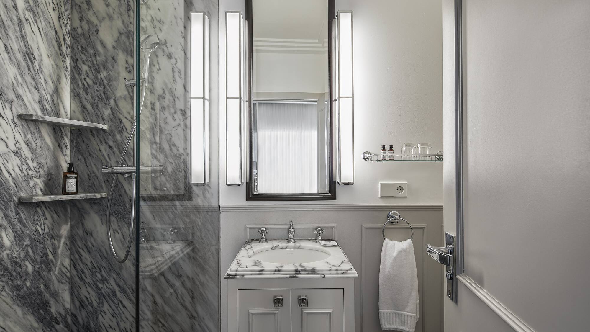 a bathroom with marble walls and a mirror