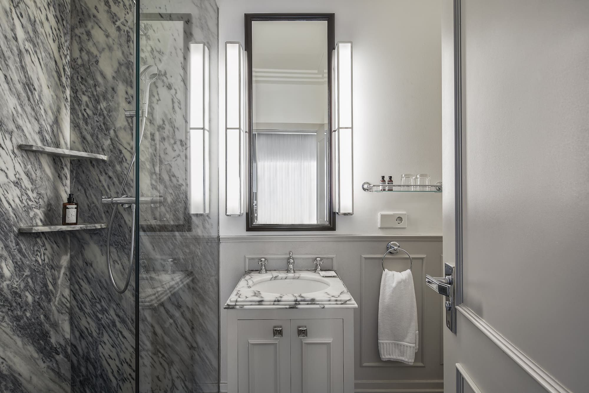 a bathroom with marble walls and a mirror