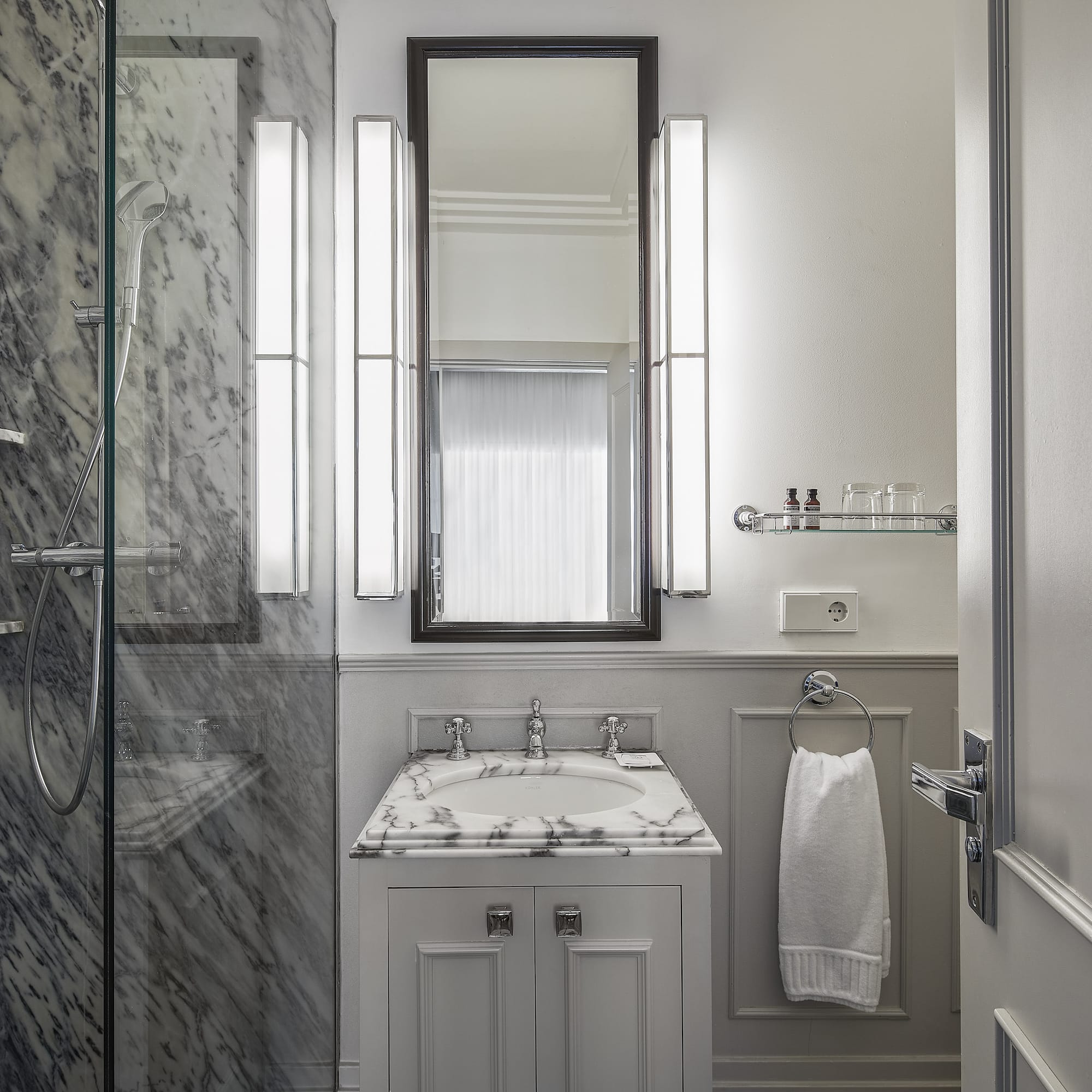 a bathroom with marble walls and a mirror