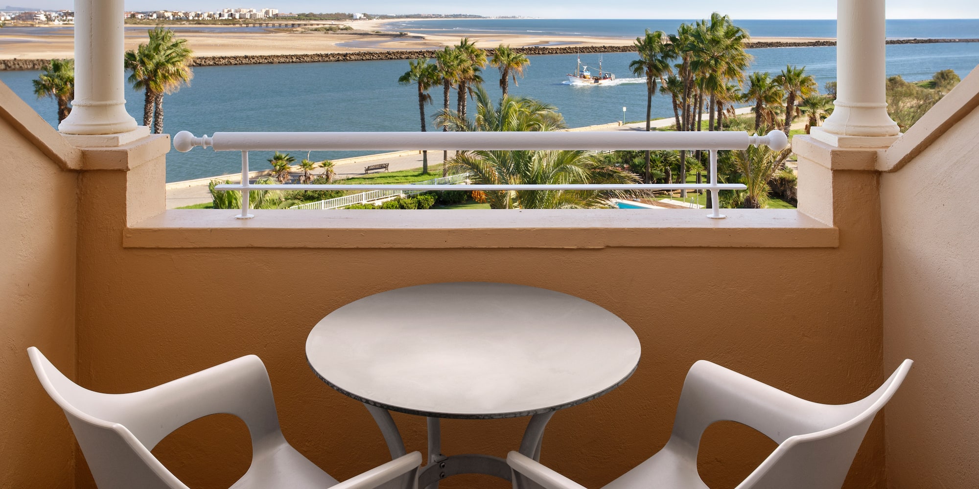 a table and chairs on a balcony overlooking a body of water