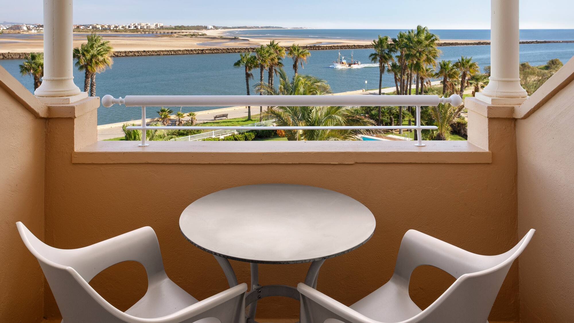 a table and chairs on a balcony overlooking a body of water