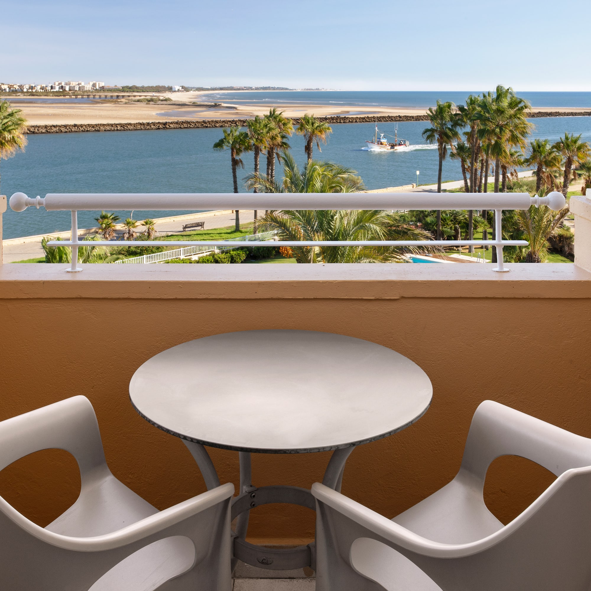 a table and chairs on a balcony overlooking a body of water