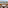 Resort balcony with seating, ocean view, palm trees, and boat.