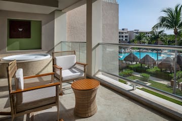 a balcony with a jacuzzi and chairs