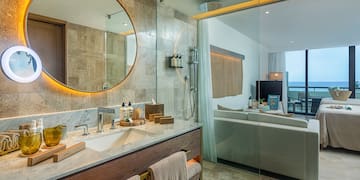 a bathroom with a large round mirror and a bathtub