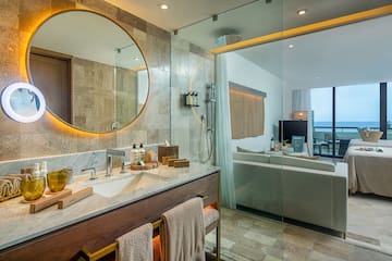 a bathroom with a large round mirror and a bathtub