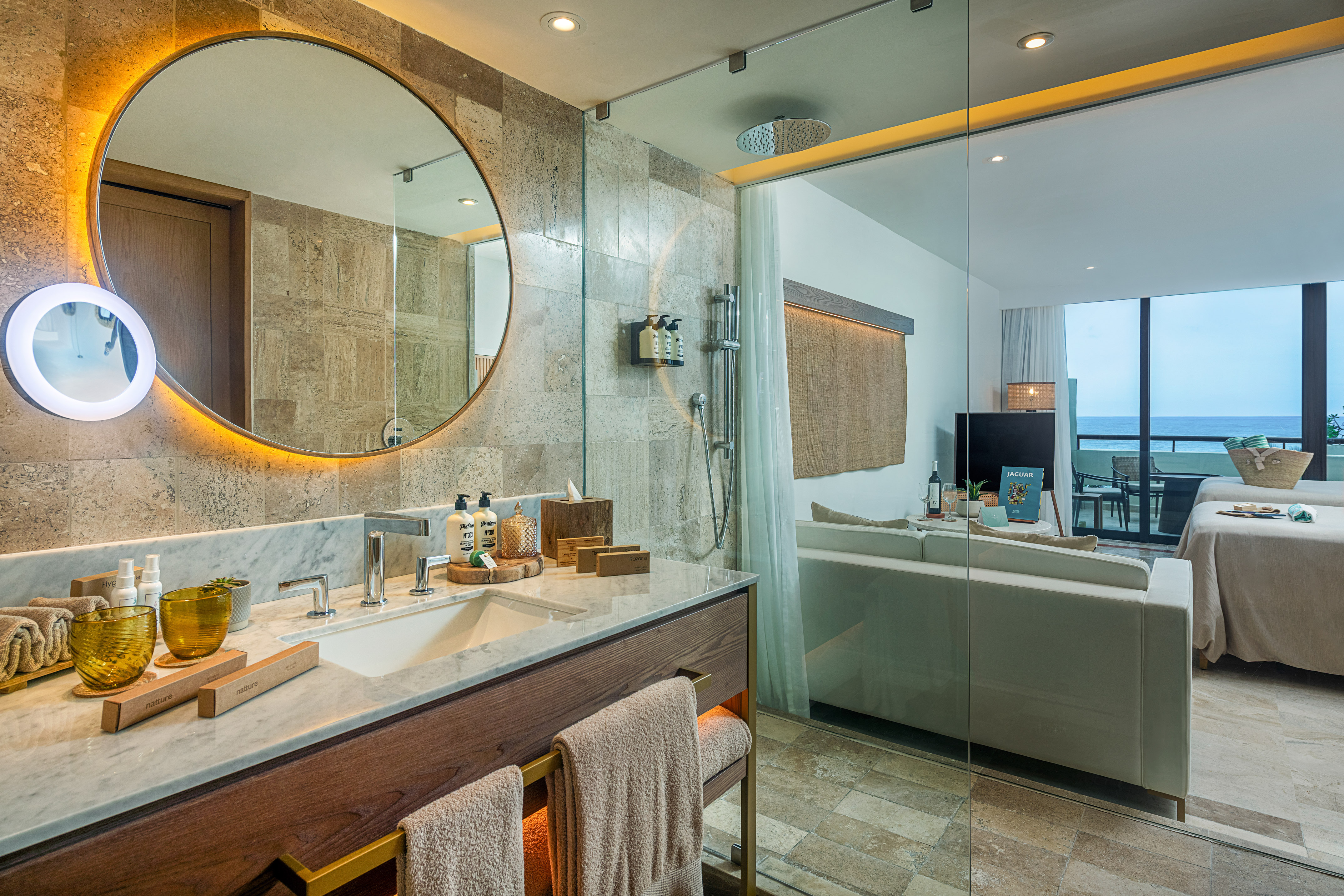 a bathroom with a large round mirror and a bathtub