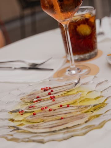 a plate of fish with red peppercorns on it