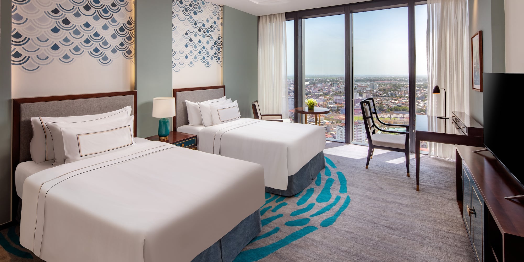 a room with two beds and a table and chairs