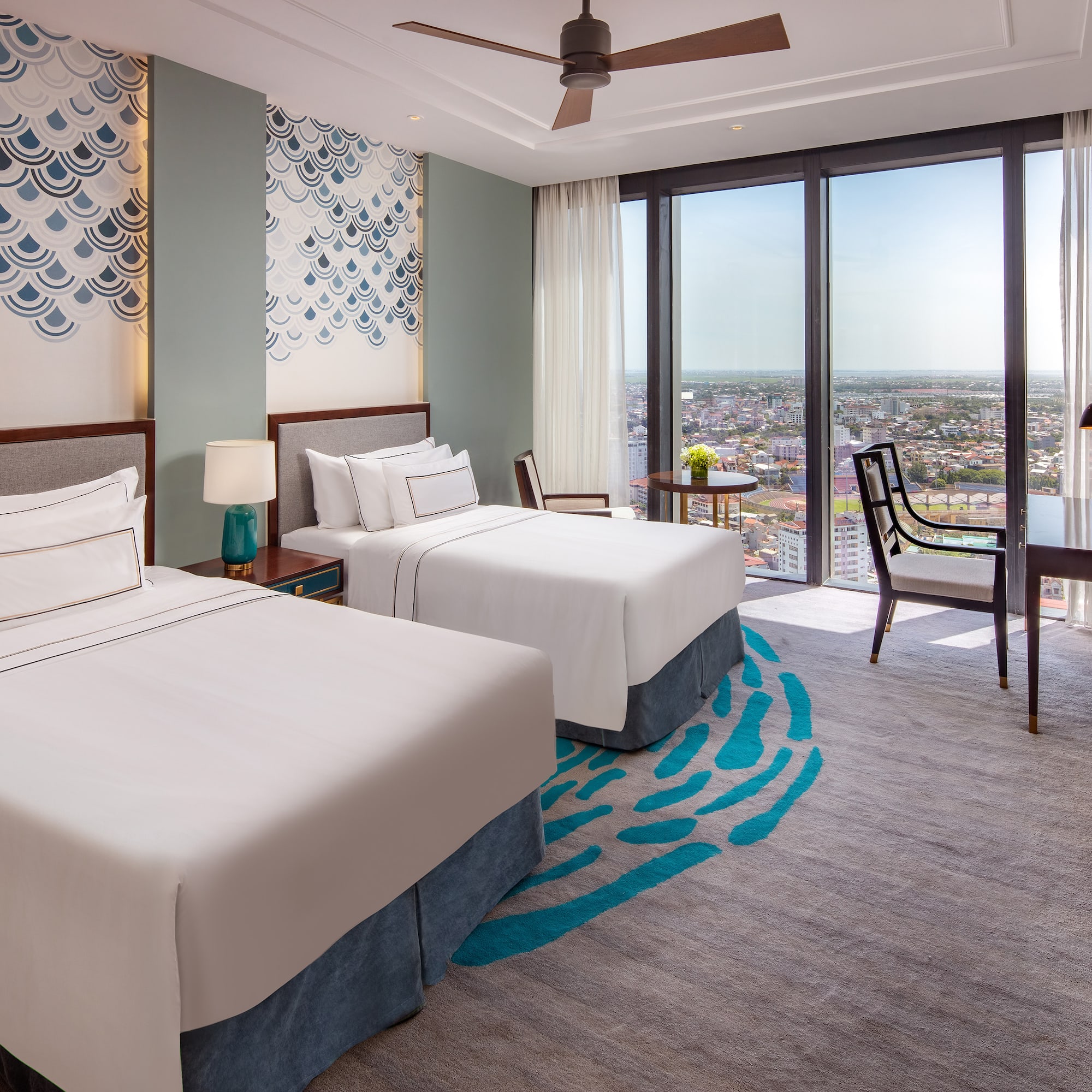 a room with two beds and a table and chairs