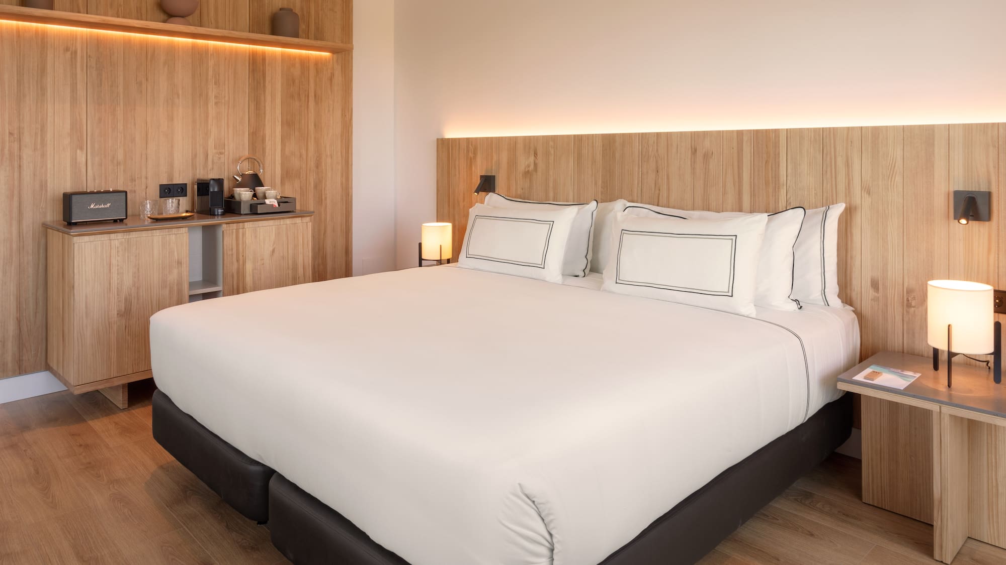 a bed with white sheets and a wood headboard