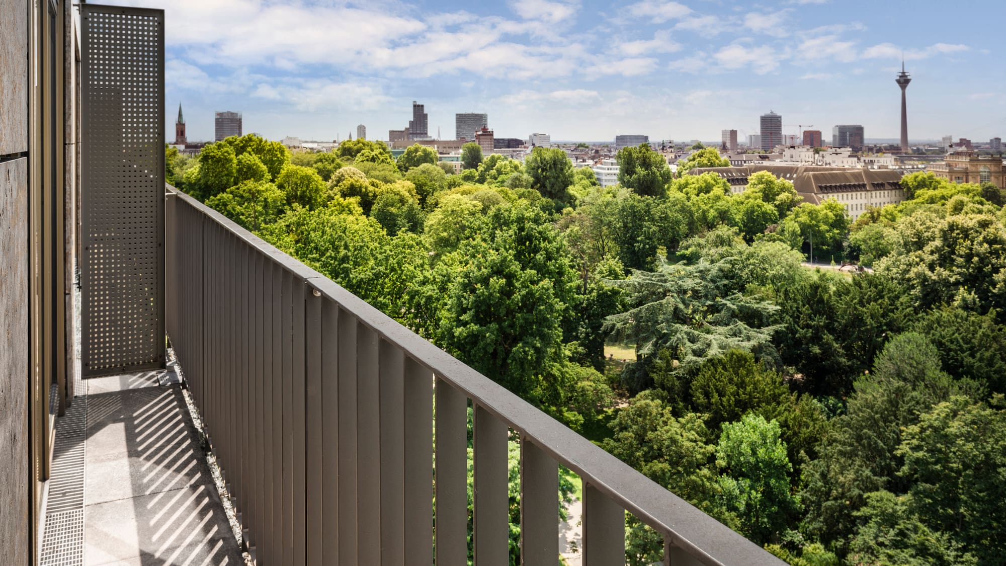 a balcony with trees and a city in the background