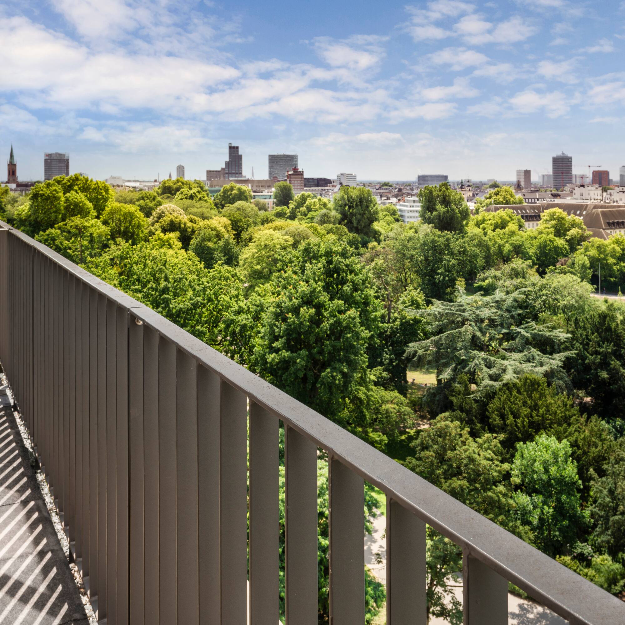 a balcony with trees and a city in the background