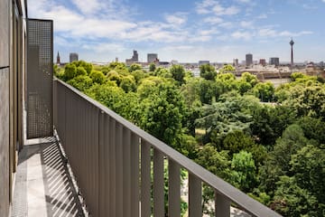 a balcony with trees and a city in the background