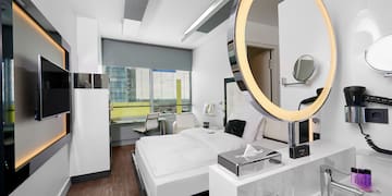 a room with a round mirror and a bed