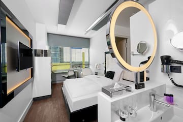 a room with a round mirror and a bed
