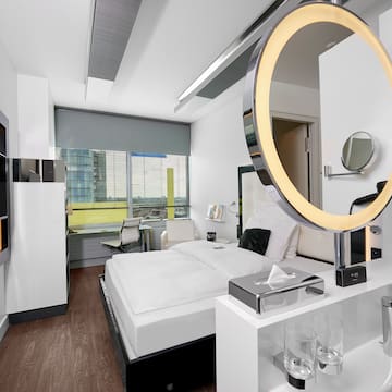 a room with a round mirror and a bed