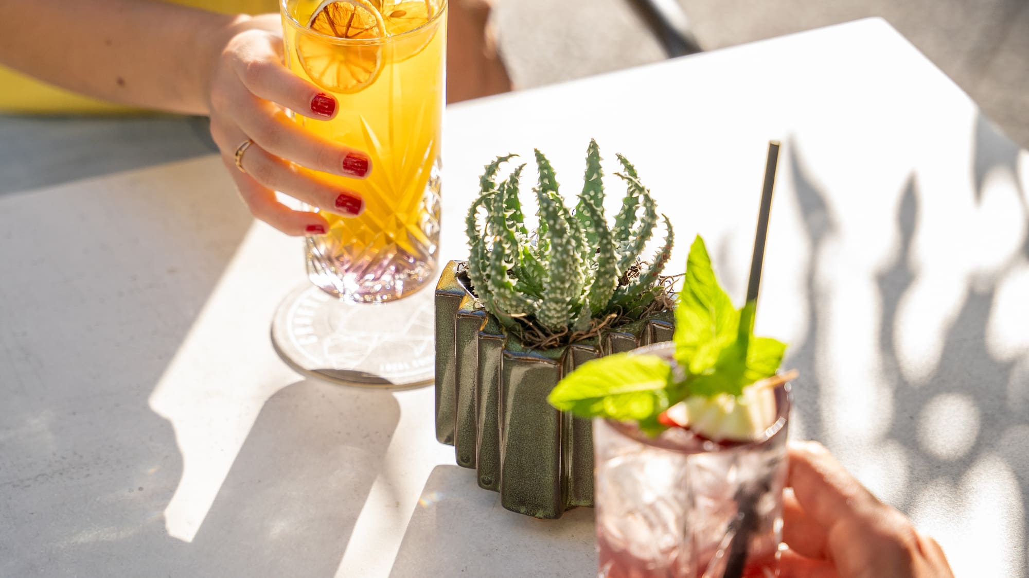 a person holding drinks with a straw