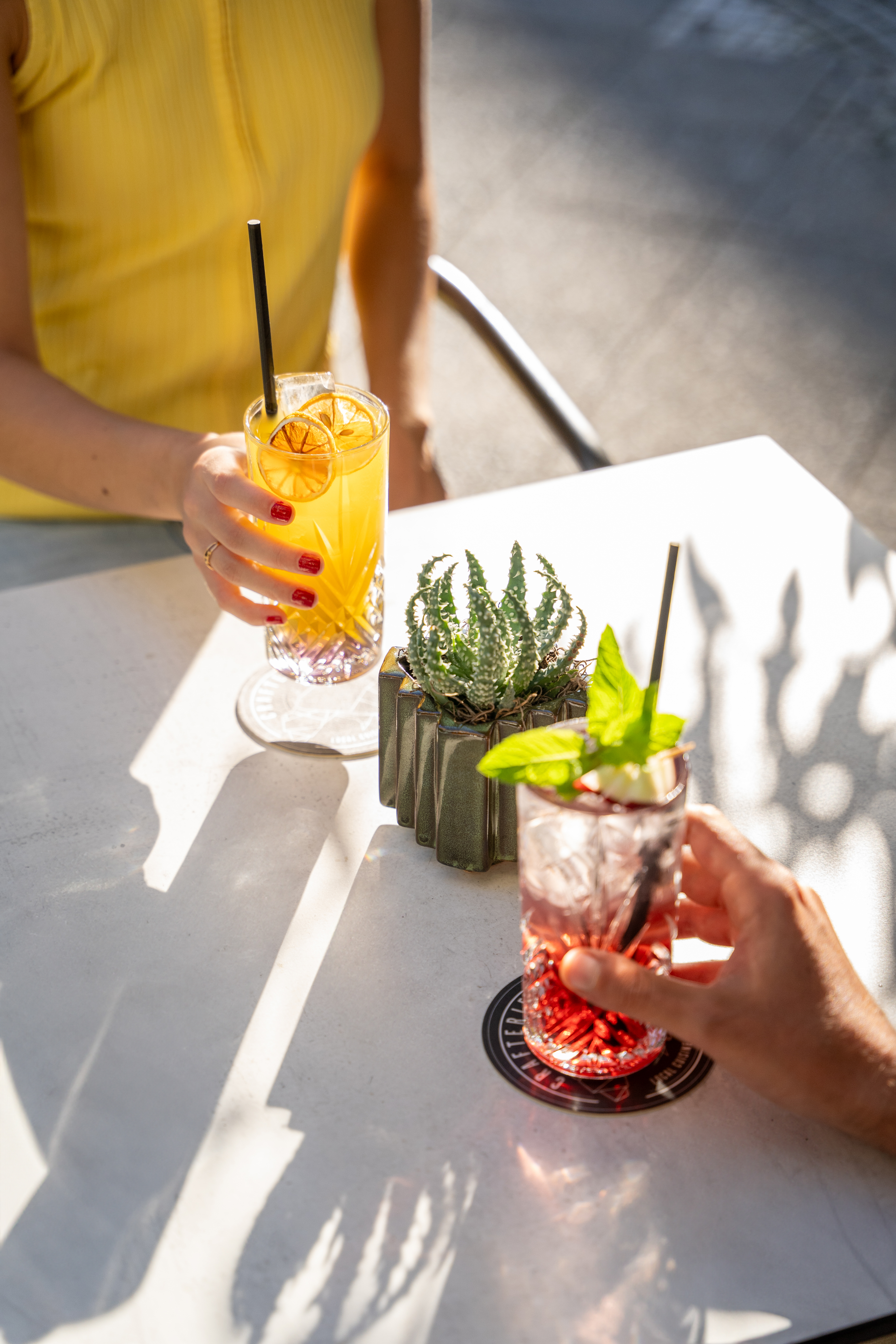 a person holding drinks with a straw