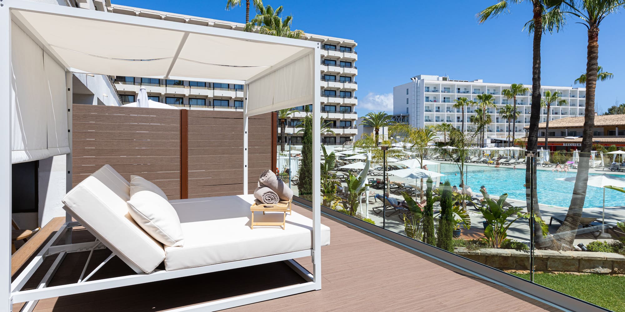 a deck with a white canopy and a pool in the background