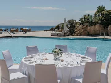 a table set for a dinner party by a pool