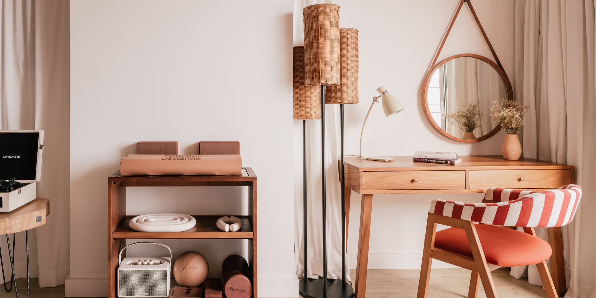 Modern interior with wooden desk, red striped chair, rattan lamp, and fitness gear.