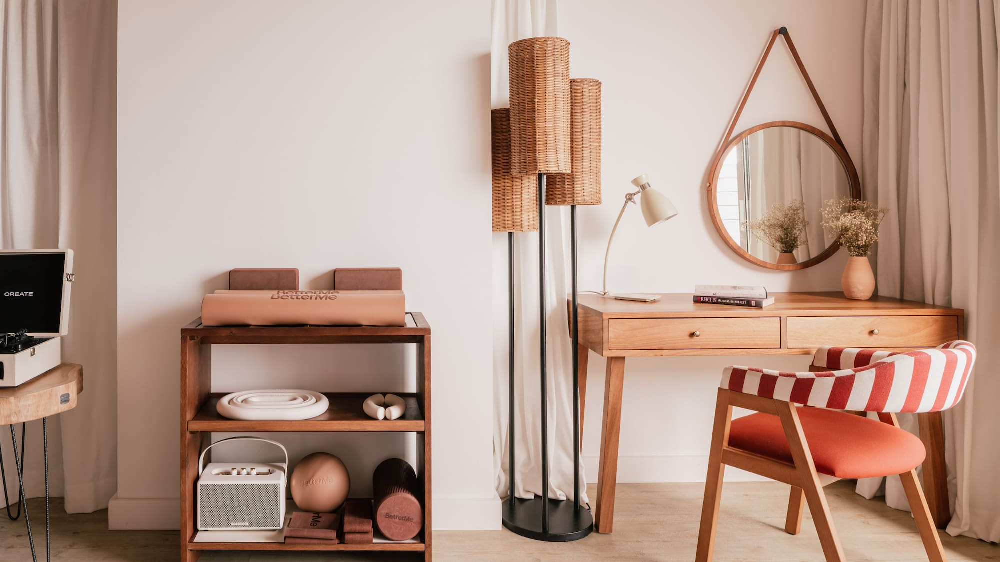 Modern interior with wooden desk, red striped chair, rattan lamp, and fitness gear.