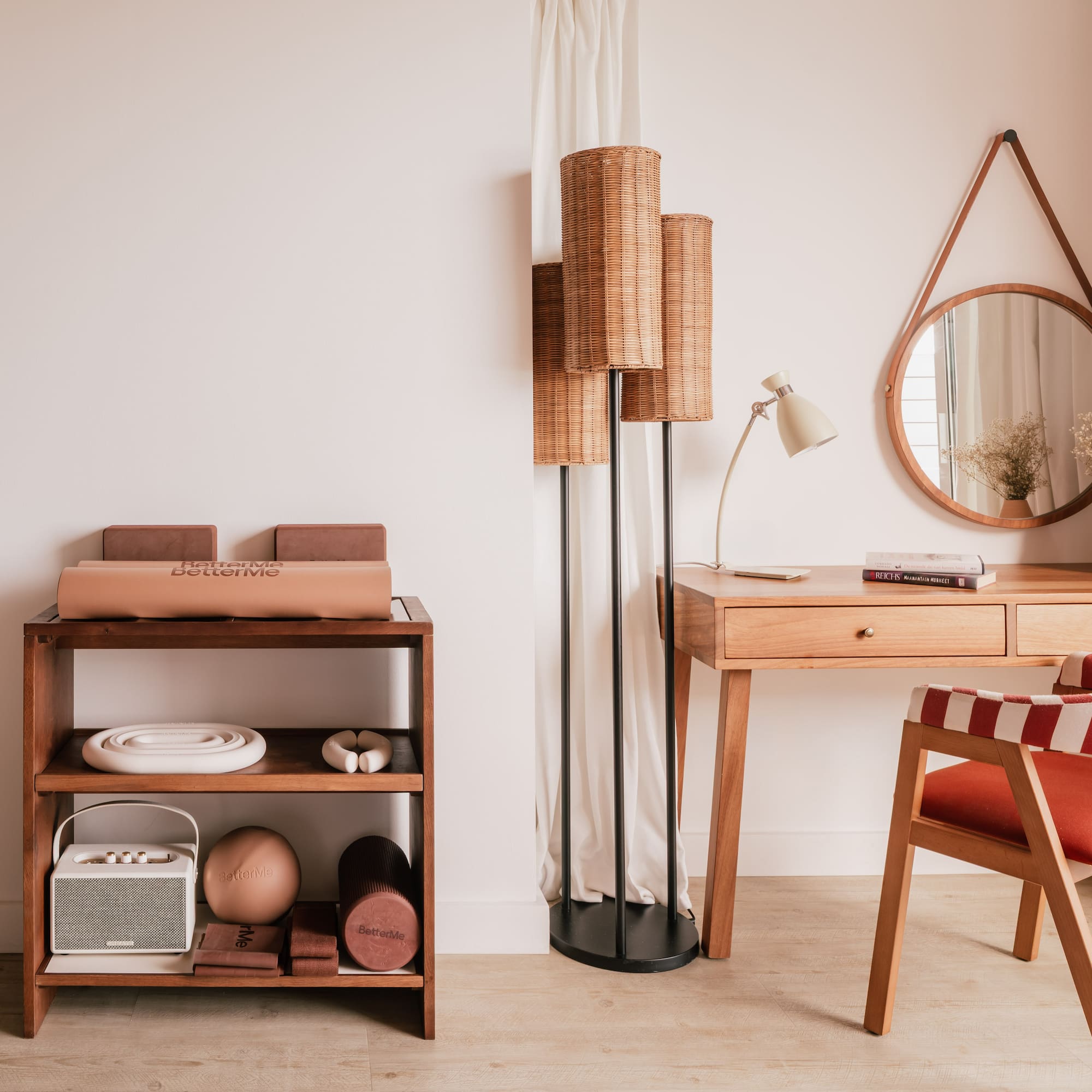 Modern interior with wooden desk, red striped chair, rattan lamp, and fitness gear.