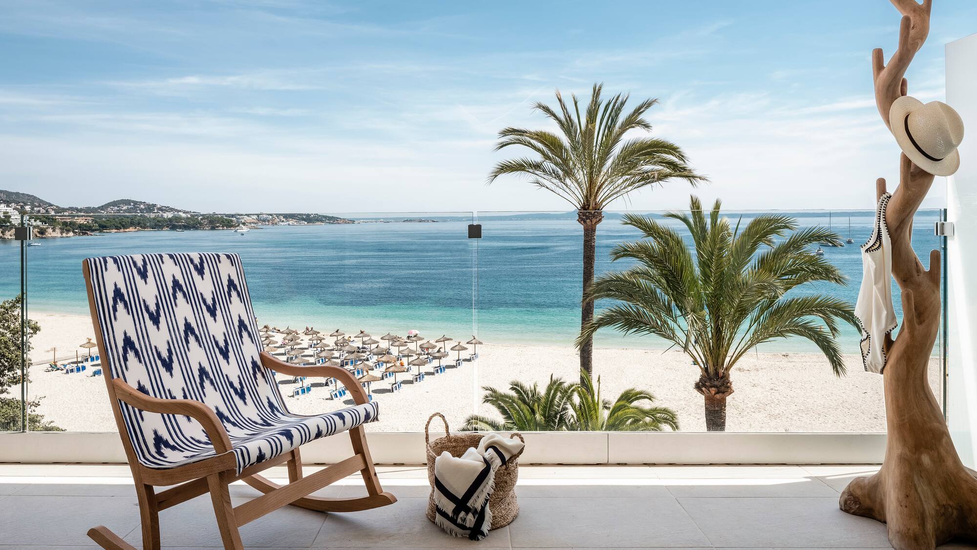 a chair on a balcony overlooking a beach