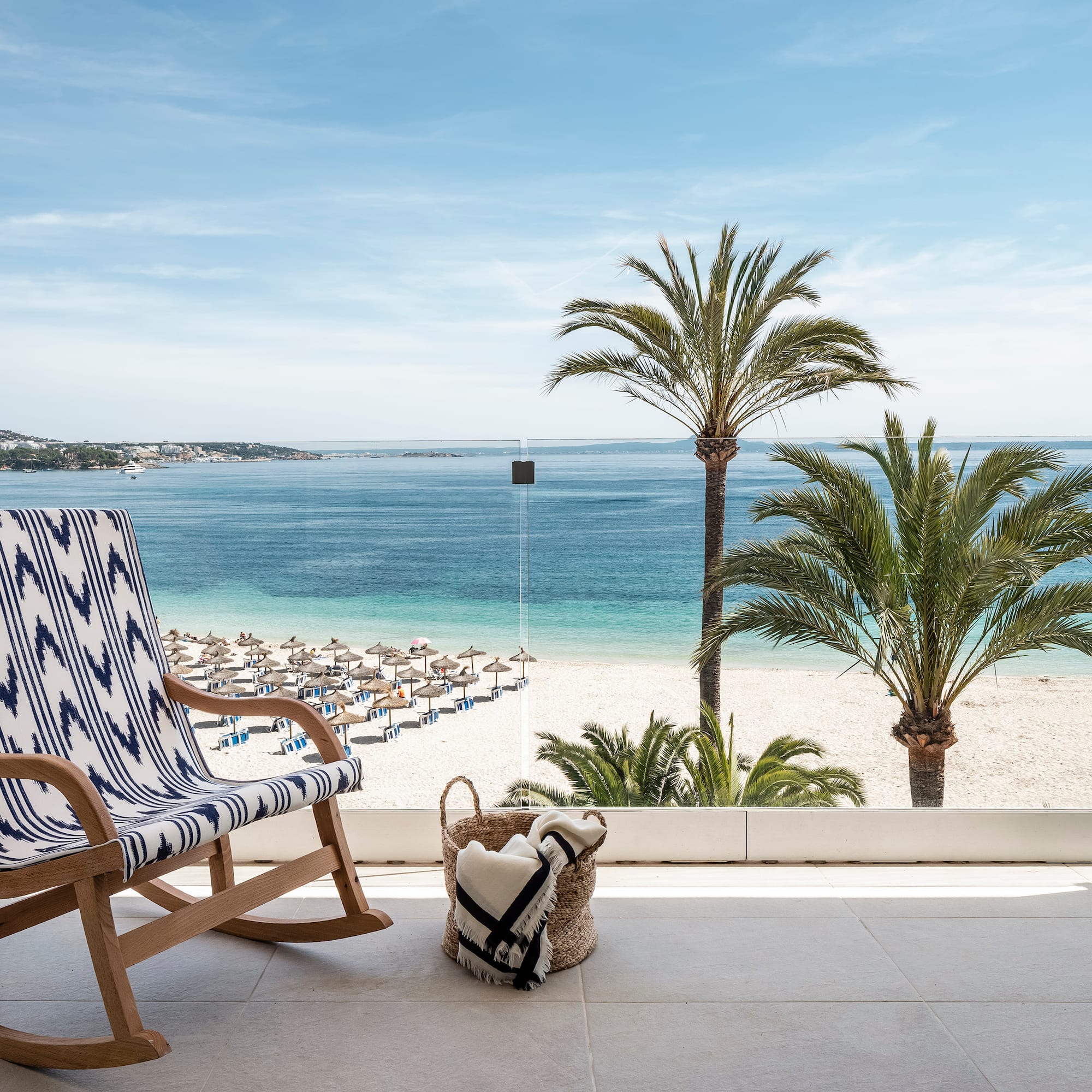 a chair on a balcony overlooking a beach