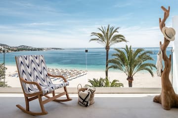 uma cadeira numa varanda com vista para a praia