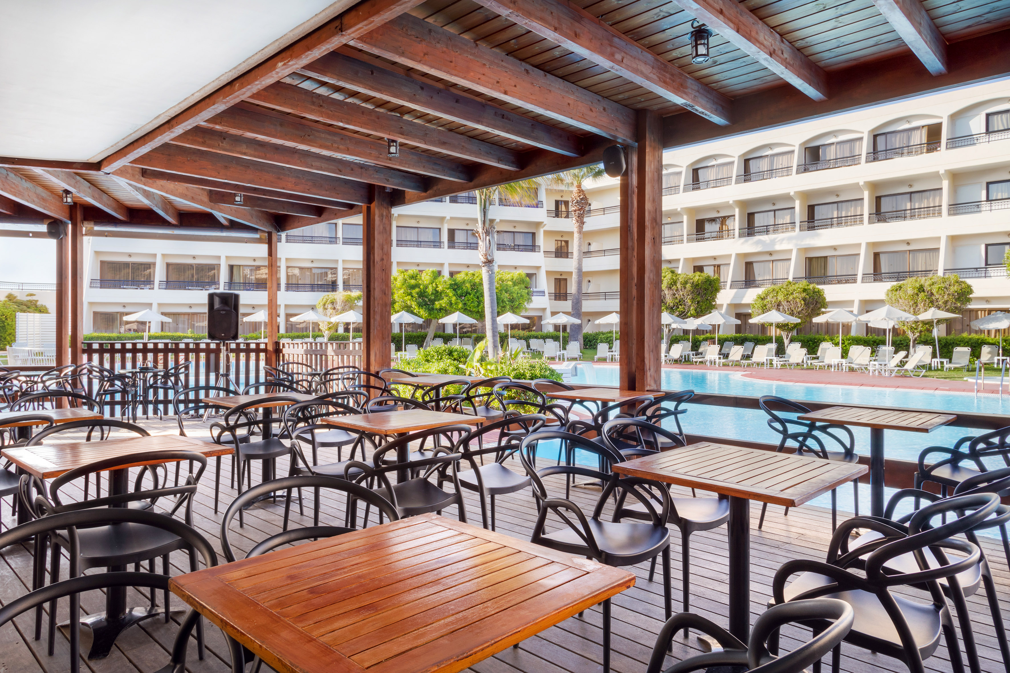 a patio with tables and chairs and a pool