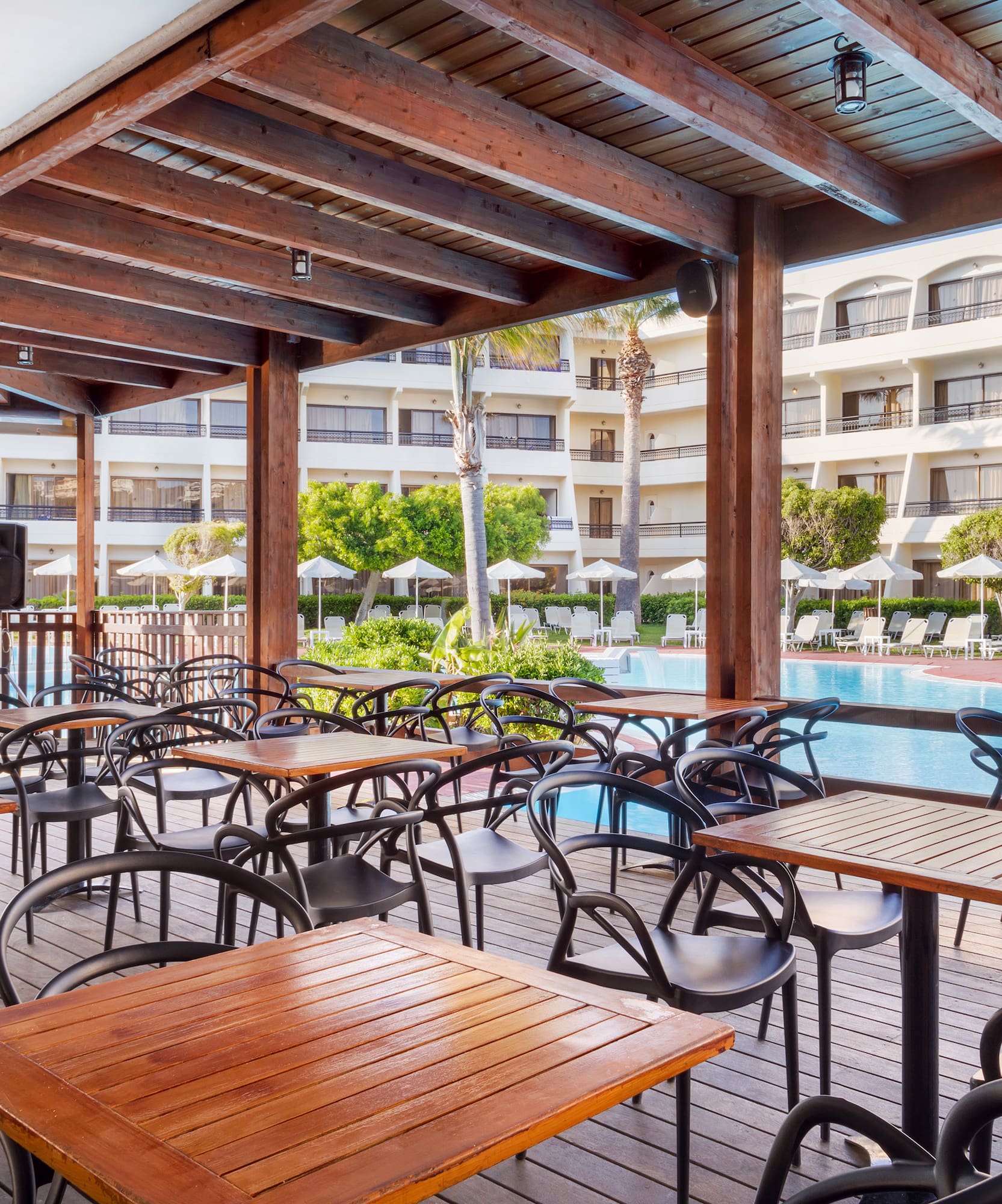 a patio with tables and chairs and a pool