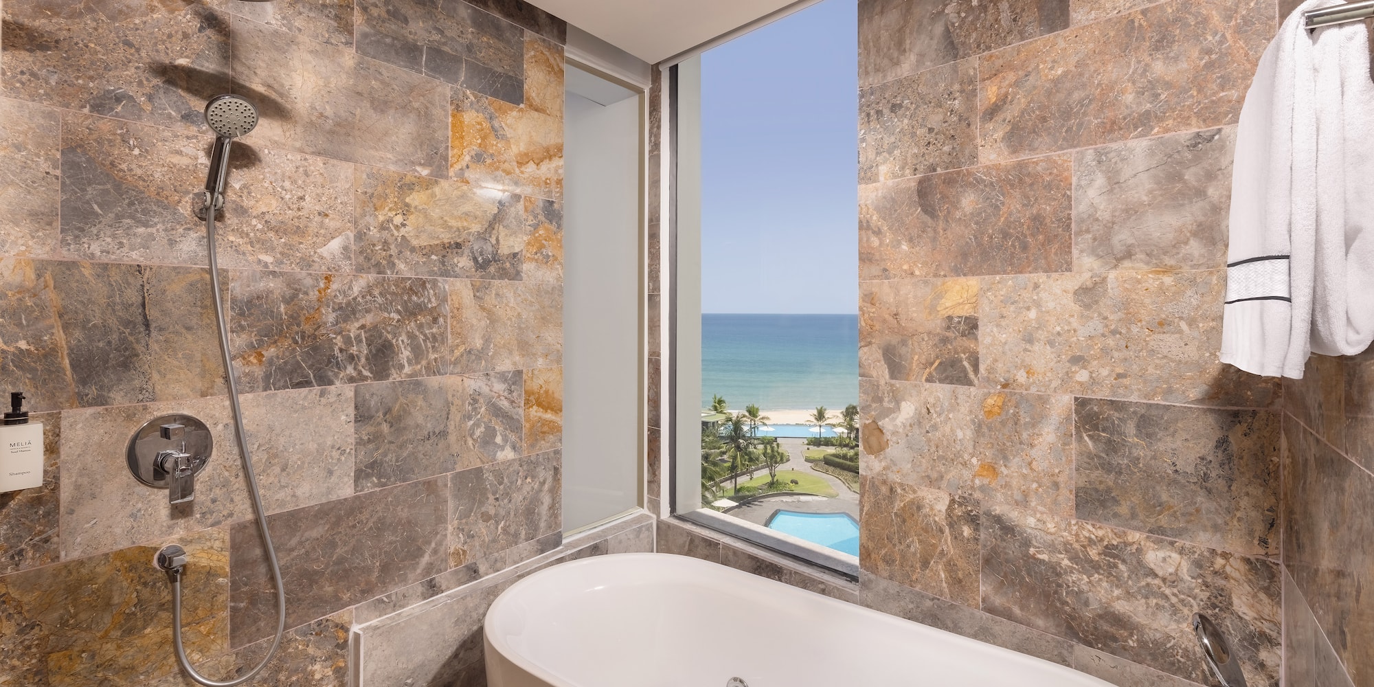 a bathroom with a bathtub and a view of the ocean